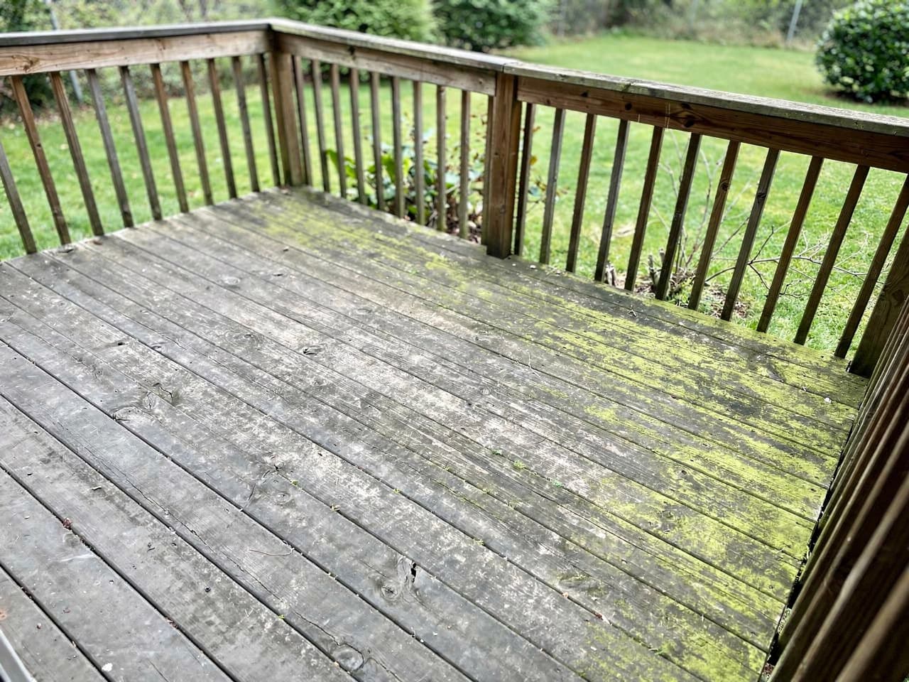 A wood deck gone gray and slick with algae before cleaning